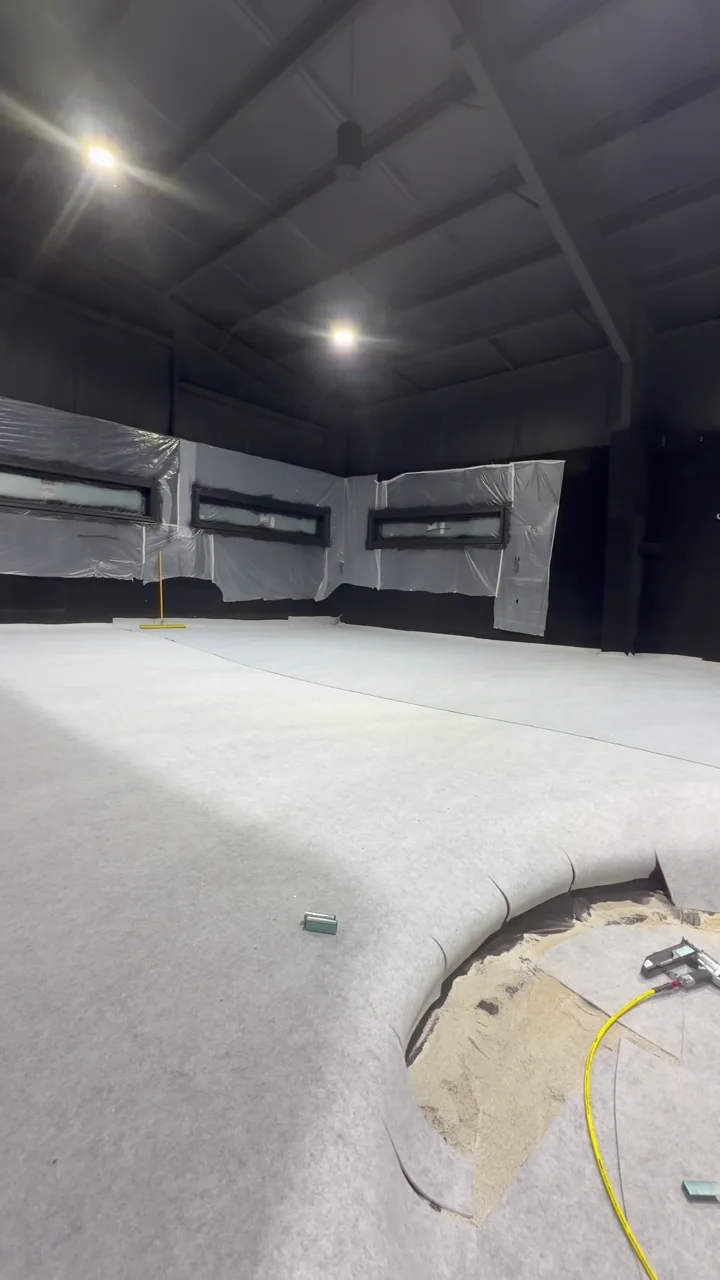 The curved main floor area during construction, with temporary protection and loose materials