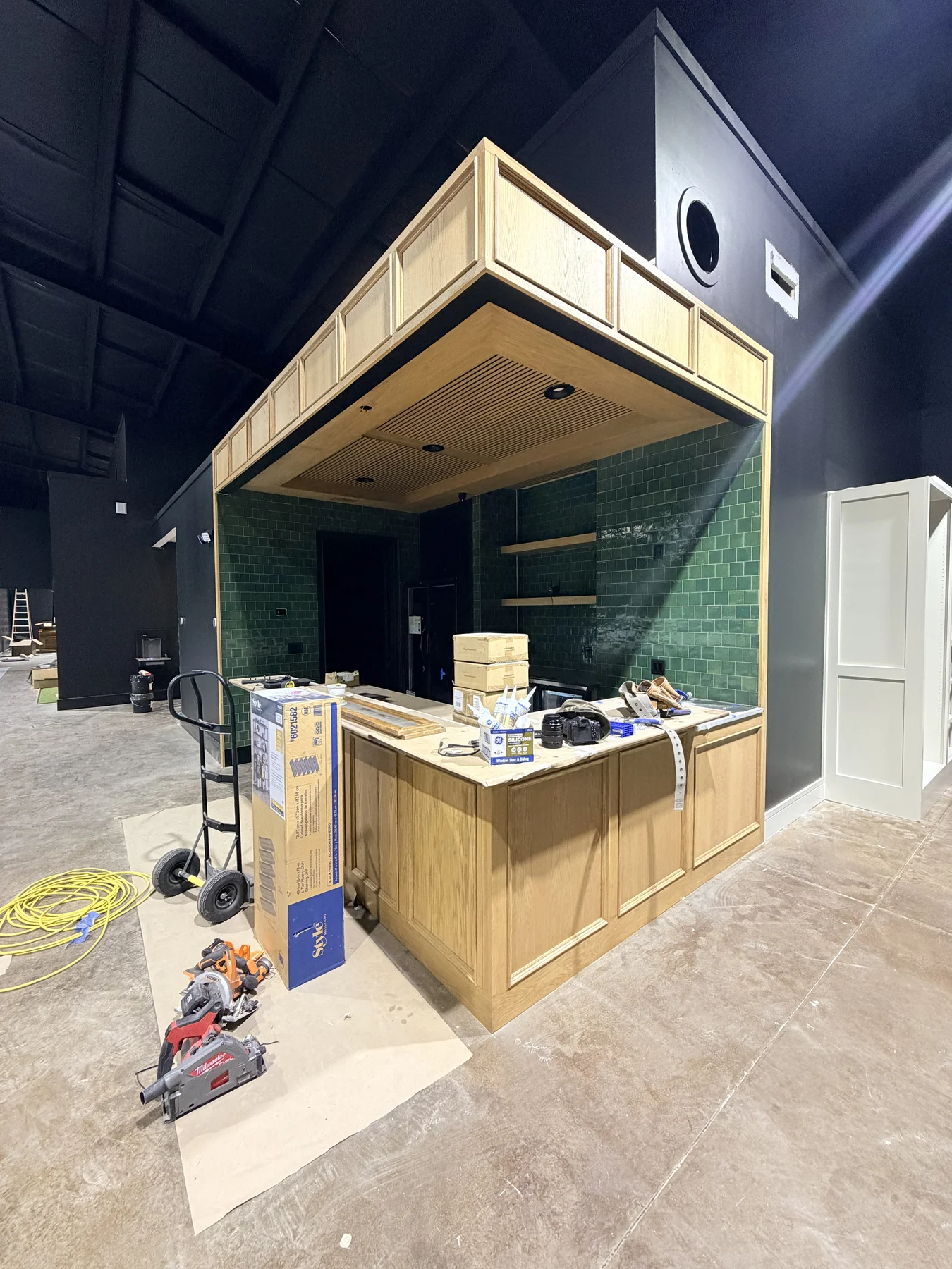 Dogwood timber and green tile bar during construction in October 2026